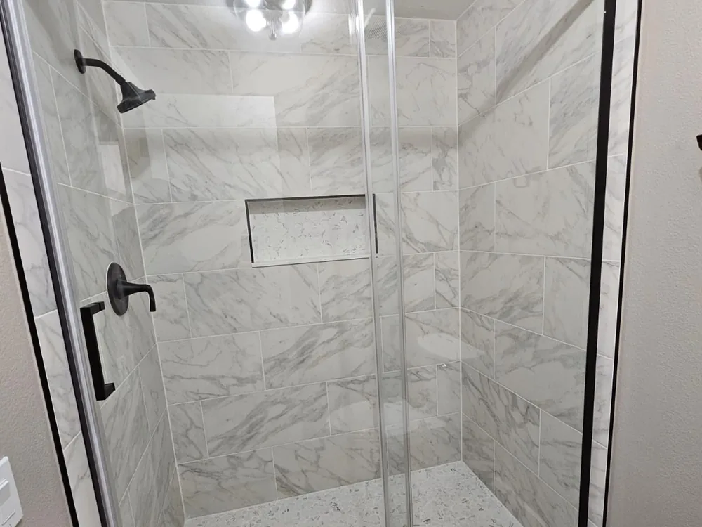 Marble-look tile in a completed frameless shower