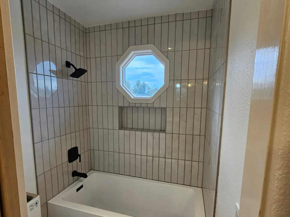 Completed bathroom tub surround with vertical tile