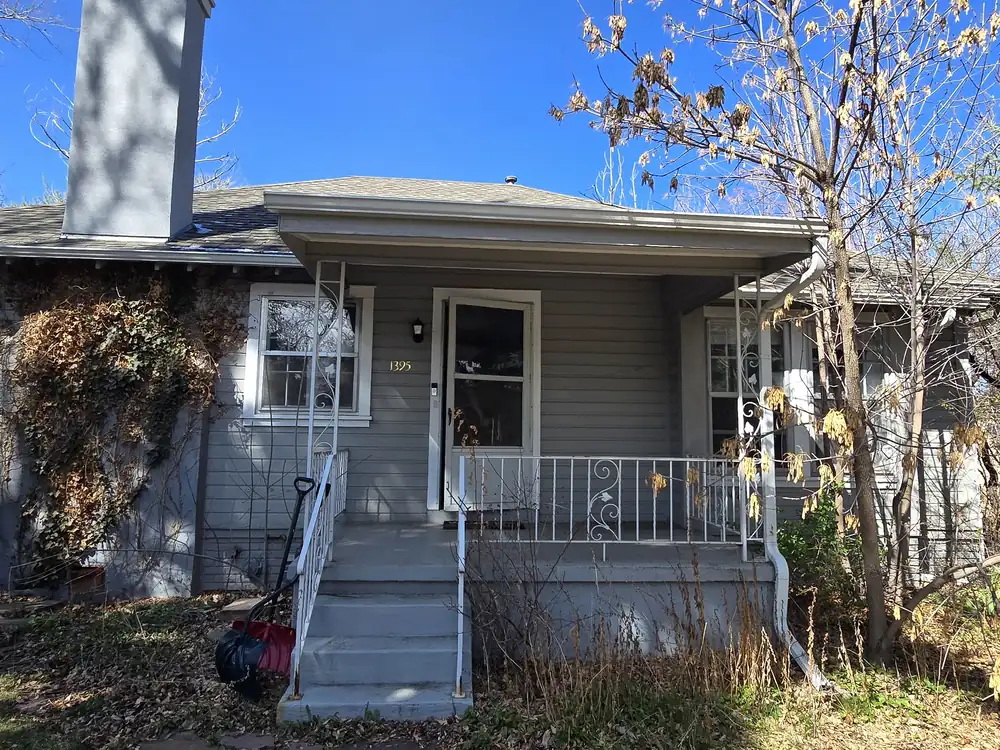 Wide view of a weathered home and porch before renovation