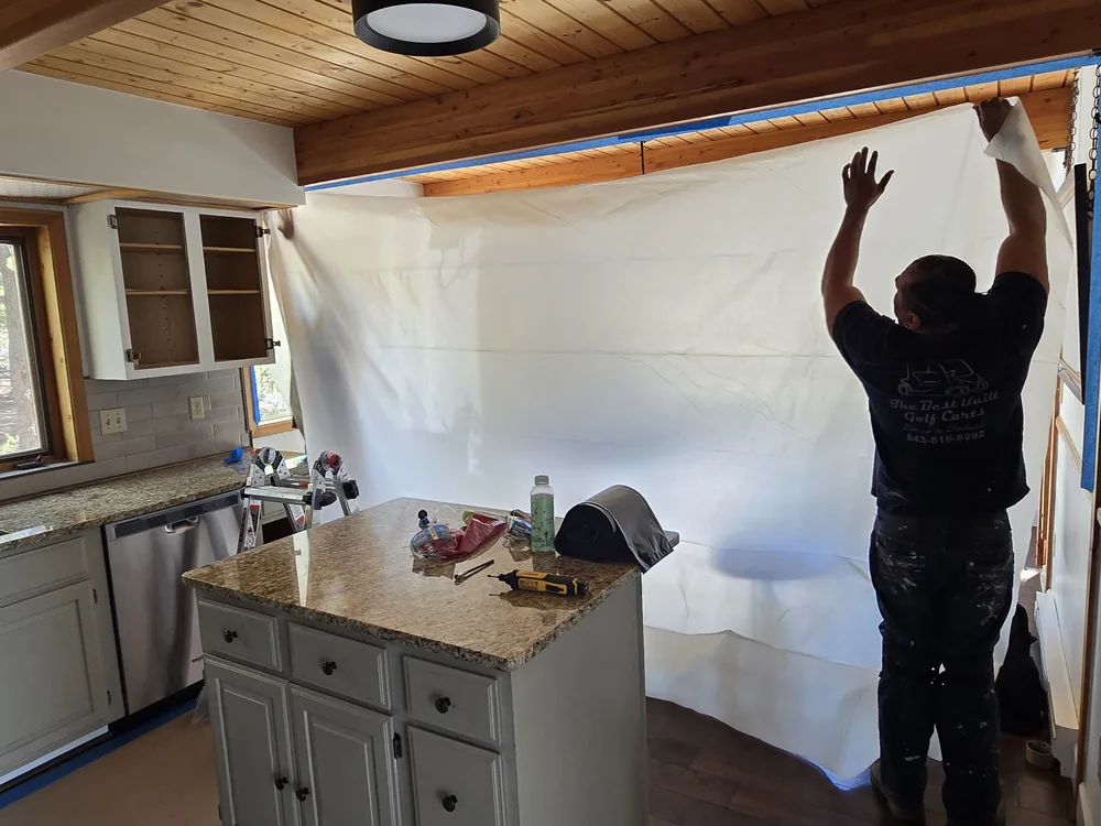 Painter masking a kitchen before painting